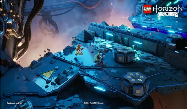 Capture d'écran du jeu LEGO Horizon Adventures montrant un monde ouvert coloré rempli de constructions LEGO, avec un personnage LEGO d'Aloy chevauchant une machine mécanique dans un paysage post-apocalyptique fait de briques