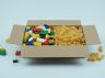 Boîte Lego ouverte avec des pâtes alimentaires à la place des briques,  illustration de la technique de fraude au remboursement